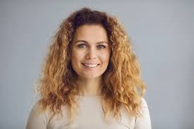 Person with curly hair, neutral background.